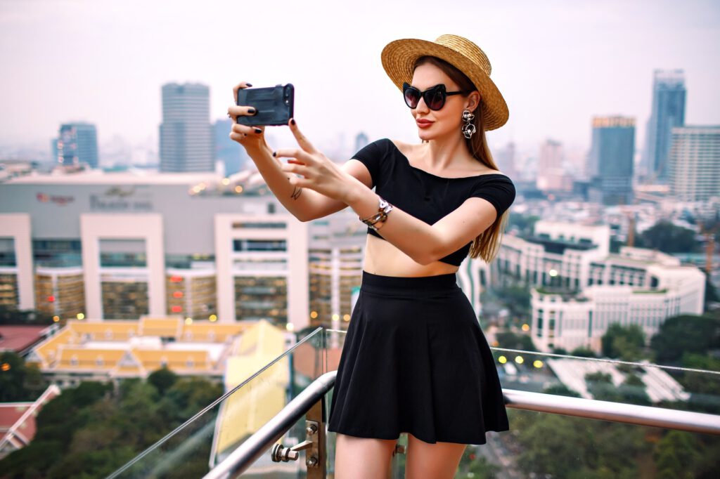 Frau von hinten auf Dachterrasse mit Blick auf Bangkok