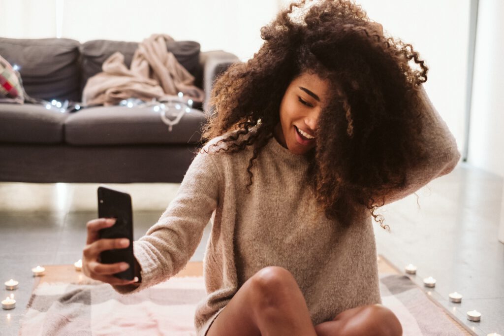 OnlyFans Selfie Content: Sinnliche schwarze Frau macht Selfie am Boden liegend