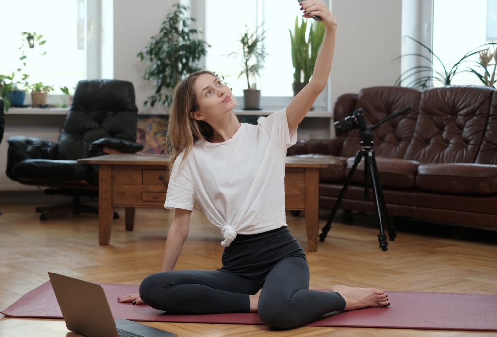 Stilvolle Frau macht Selfie mit Handy in modernem Raum
