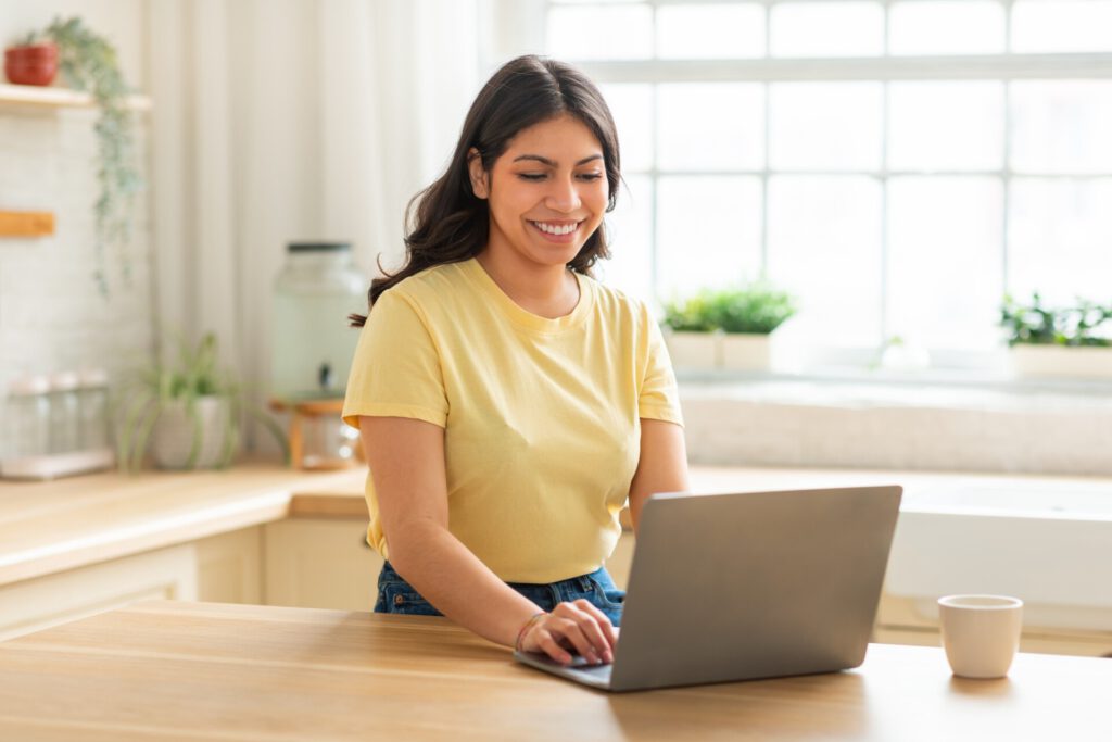 OnlyFans Creator Alltag: Frau beginnt Tag mit Laptop-Arbeit zu Hause